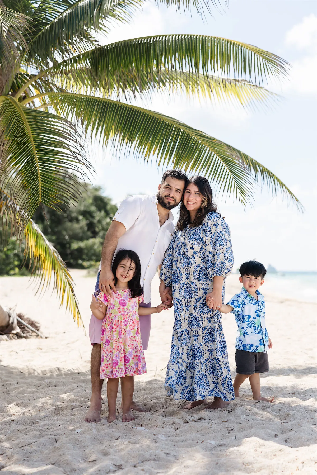 Family standing under palm trees during a Cozumel vacation photo session