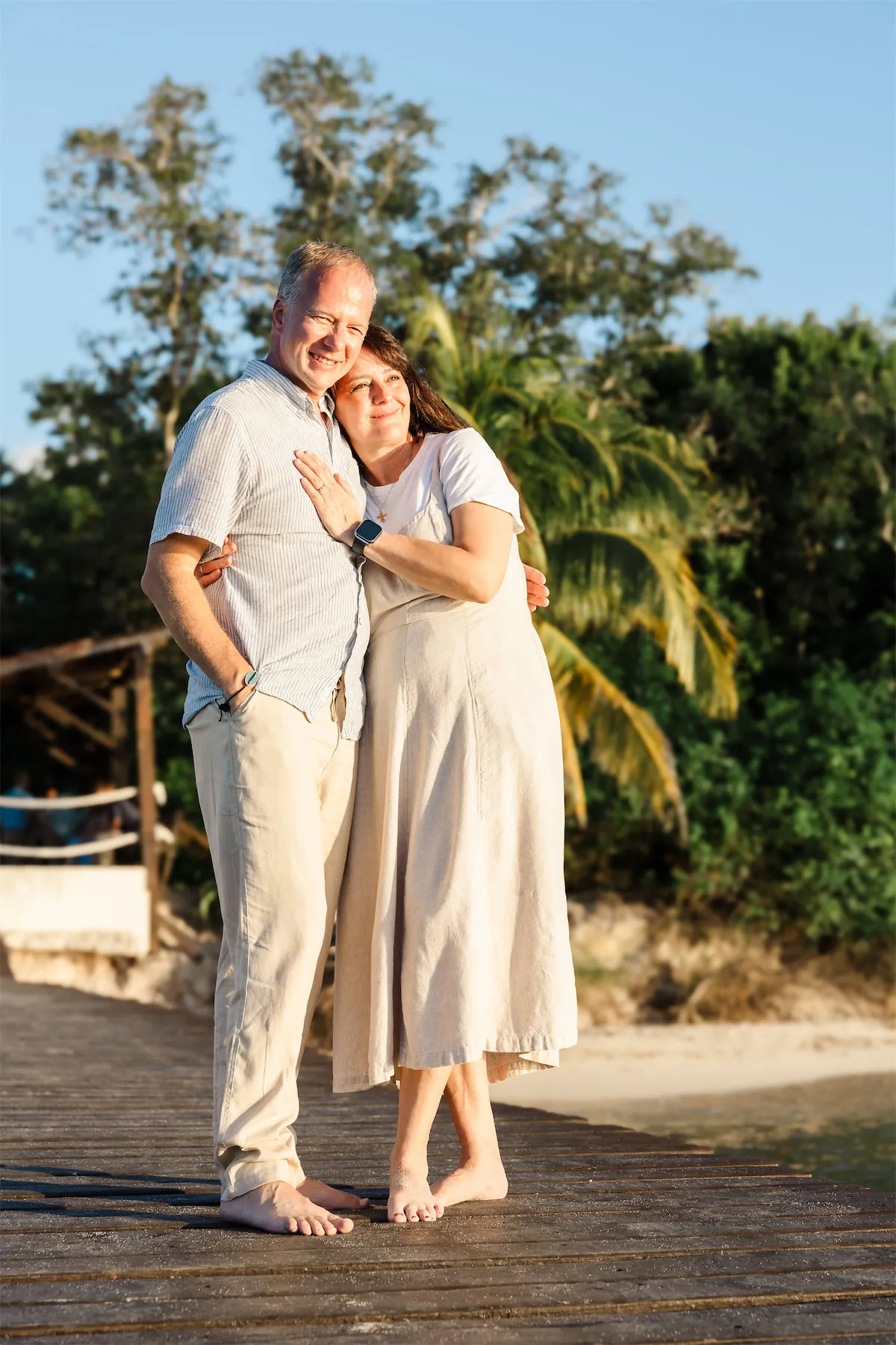 A happy couple embracing on a wooden pier overlooking the ocean at the Occidental Resort in Cozumel, Mexico.